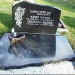Grabmal aus scharzem Granit mit Abdeckplatte und Blumenornament