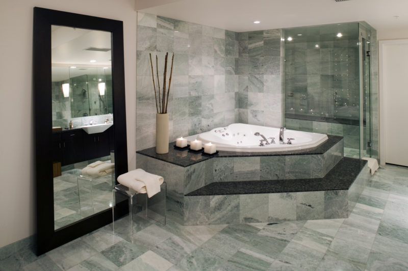 Badezimmer, in dem grüner und schwarzer Naturstein wunderschön kombiniert wurden.