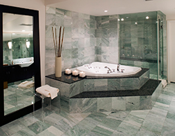 Badezimmer, in dem grüner und schwarzer Naturstein wunderschön kombiniert wurden.