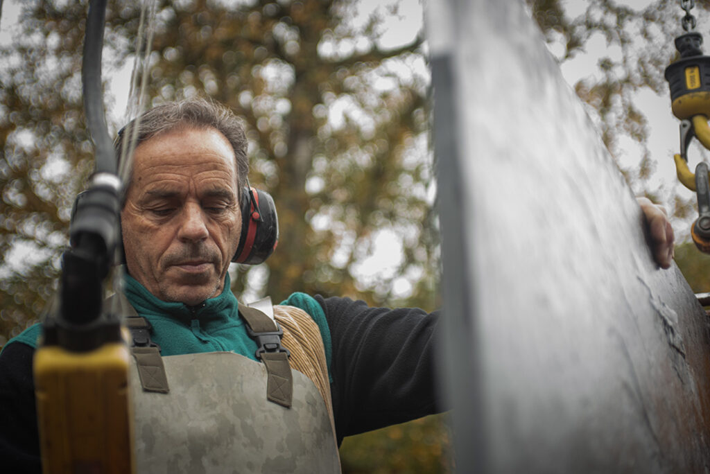 Steinmetz m Manövrieren einer großformatigen Natursteinplatte im Außenbereich