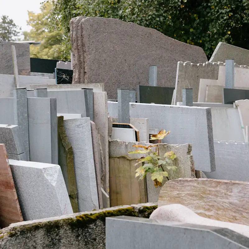 Natursteinmaterialien in verschiedenen Farben und Formaten auf dem Lagerplatz eines Steinmetzbetriebs