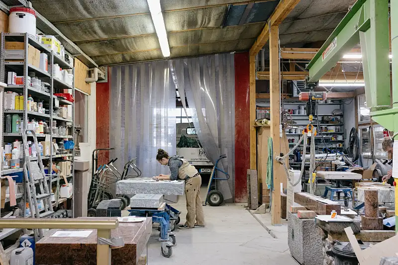 Handwerkliche Arbeit an einem Naturstein-Grabmal in der Steinmetzwerkstatt