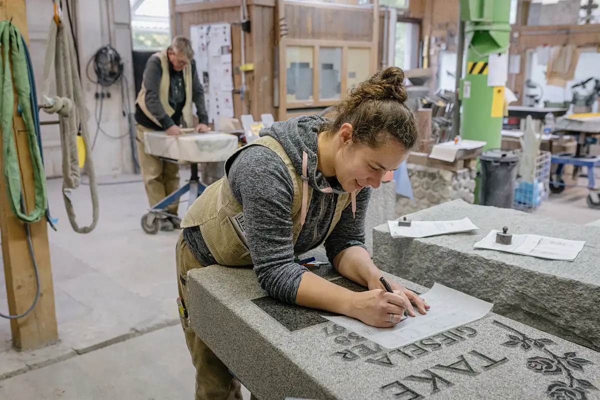 Handwerkliche Arbeit an einem Naturstein-Grabmal in der Steinmetzwerkstatt